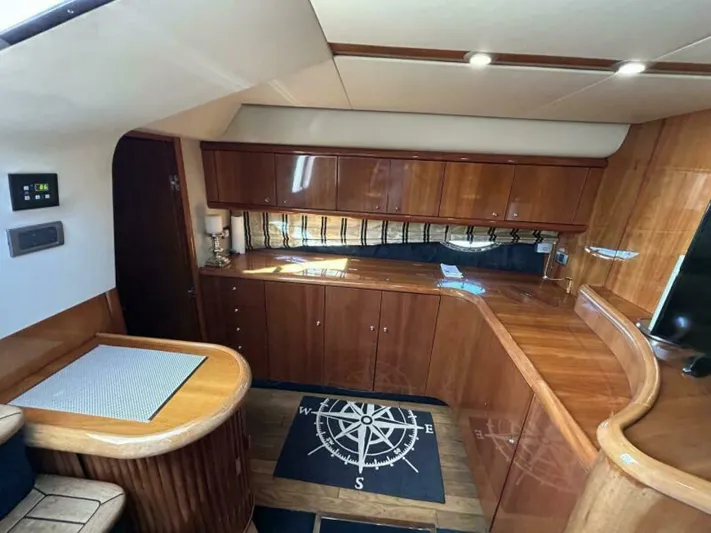  Yacht Photos Pics Interior of 2003 Sunseeker 50 Camargue yacht with wooden cabinetry and compass-themed rug.