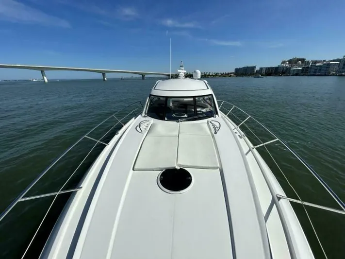  Yacht Photos Pics 2003 Sunseeker 50 Camargue yacht on calm waters near a bridge and cityscape.