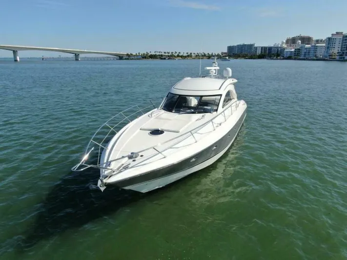  Yacht Photos Pics 2003 Sunseeker 50 Camargue yacht cruising near a coastal city.