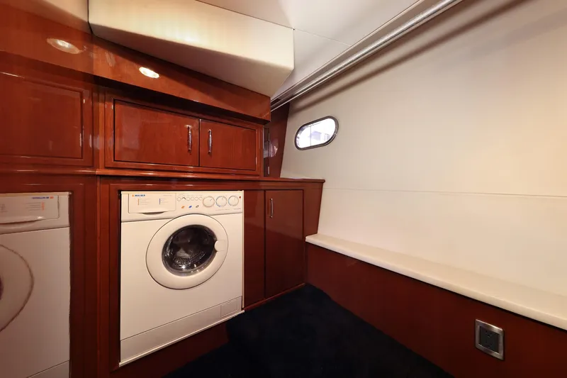Tuff Ship Yacht Photos Pics Laundry area in 2007 Marquis 65 yacht with washer, dryer, and storage cabinets.