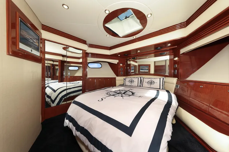 Tuff Ship Yacht Photos Pics Luxurious bedroom interior of 2007 Marquis 65 yacht with elegant wood finishes and nautical bedding.