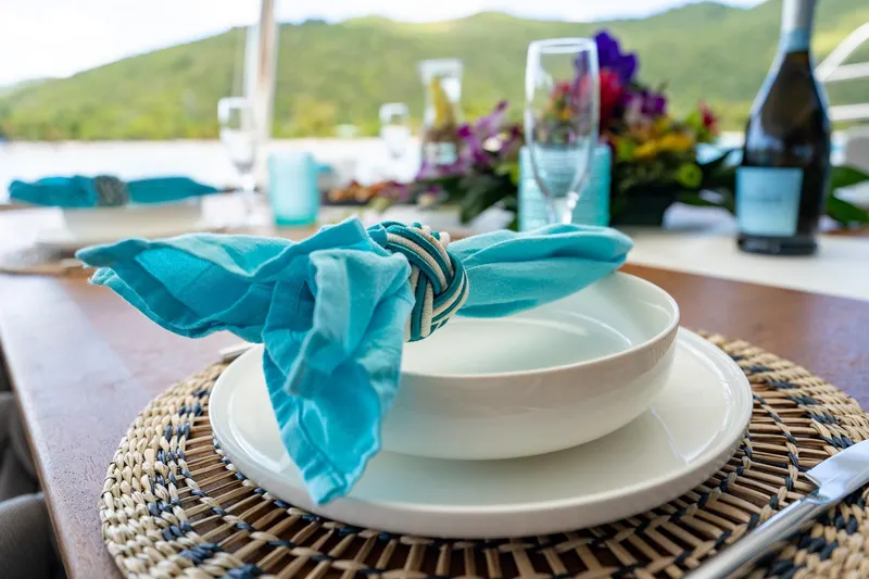 Jewel Yacht Photos Pics Elegant table setting on 2023 Fountaine Pajot Alegria yacht, featuring turquoise napkin and scenic view.