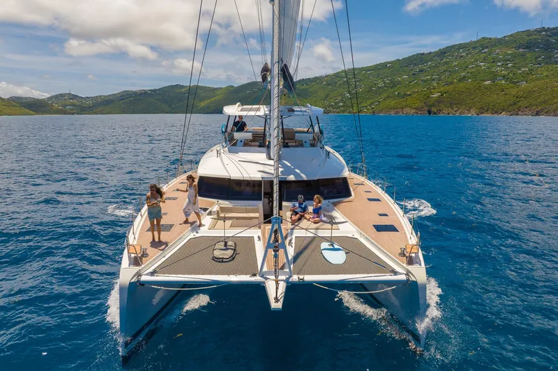 Jewel Yacht Photos Pics 2023 Fountaine Pajot Alegria catamaran sailing in scenic blue waters with passengers onboard.