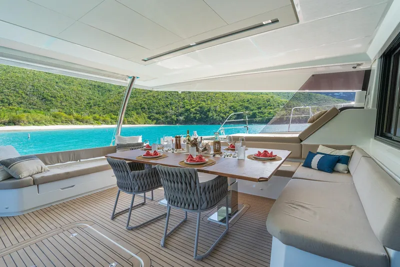 Jewel Yacht Photos Pics Luxurious 2023 Fountaine Pajot Alegria yacht deck with elegant dining setup and stunning ocean view.