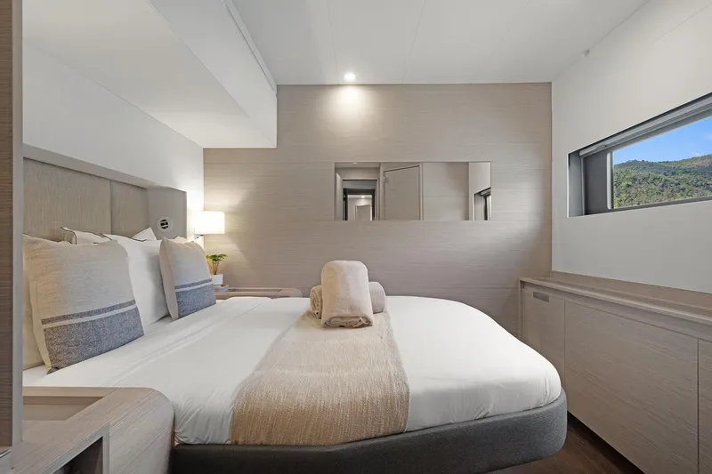 Jewel Yacht Photos Pics Luxurious bedroom interior of 2023 Fountaine Pajot Alegria yacht, featuring elegant design and scenic window view.