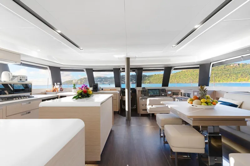 Jewel Yacht Photos Pics Luxurious interior of 2023 Fountaine Pajot Alegria yacht with modern kitchen and dining area.