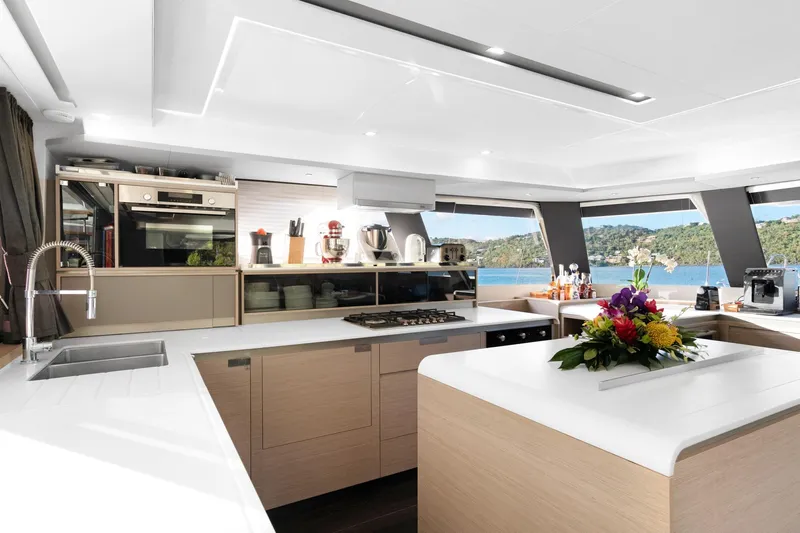 Jewel Yacht Photos Pics Luxurious 2023 Fountaine Pajot Alegria yacht kitchen with modern appliances and scenic ocean view.