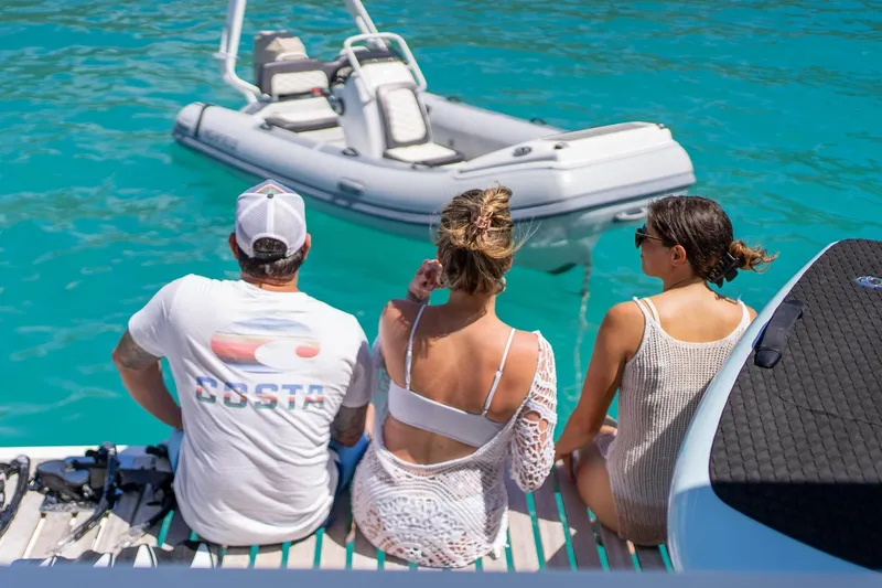 Jewel Yacht Photos Pics Three people relaxing on a 2023 Fountaine Pajot Alegria yacht, overlooking turquoise water.