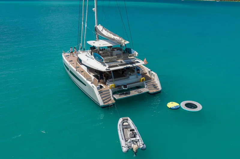Jewel Yacht Photos Pics 2023 Fountaine Pajot Alegria catamaran anchored in turquoise waters with inflatable toys nearby.