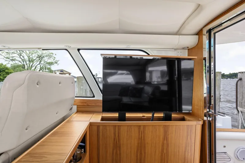 Playpen Yacht Photos Pics Interior of 2003 Tiara Yachts 5200 Sovran with TV and wooden cabinetry.