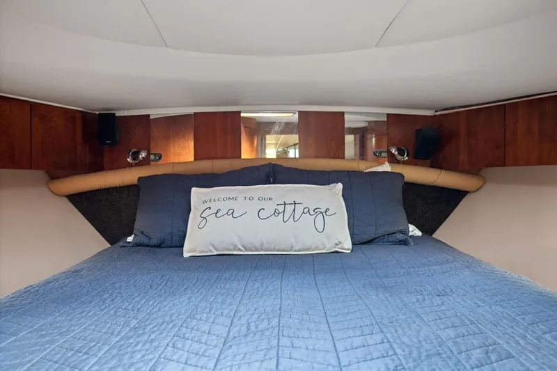 Playpen Yacht Photos Pics Cozy cabin interior of 2003 Tiara Yachts 5200 Sovran with blue bedding and decorative pillow.