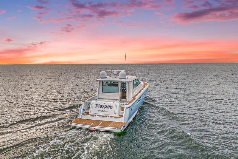 Playpen Yacht Photos Pics 2003 Tiara Yachts 5200 Sovran cruising at sunset on open water.