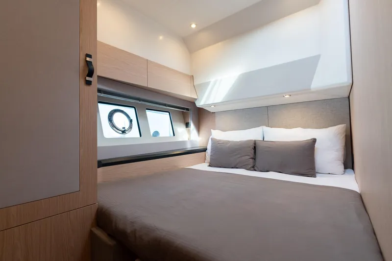 Yacht Photos Pics Luxurious cabin interior of 2022 Monte Carlo 52 yacht with modern design and cozy bedding.