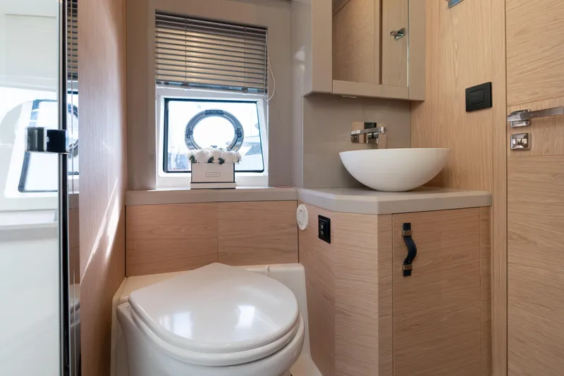  Yacht Photos Pics Modern bathroom interior on 2022 Monte Carlo 52 yacht, featuring sleek design and natural wood finishes.