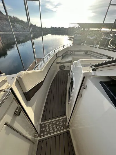  Yacht Photos Pics 2021 Formula 380 Super Sport Crossover boat with sleek deck design, docked by calm waters.