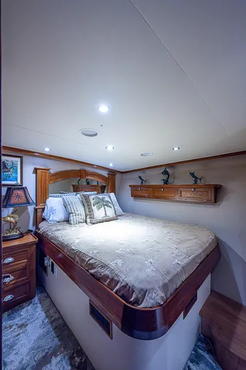 Will Rise Yacht Photos Pics Luxurious bedroom interior of a 2005 Custom Carolina 58 yacht with elegant bedding and wooden accents.
