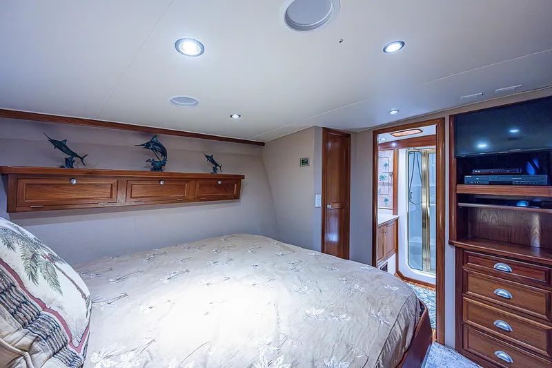 Will Rise Yacht Photos Pics Luxurious bedroom in a 2005 Custom Carolina 58 yacht with wooden cabinetry and modern lighting.