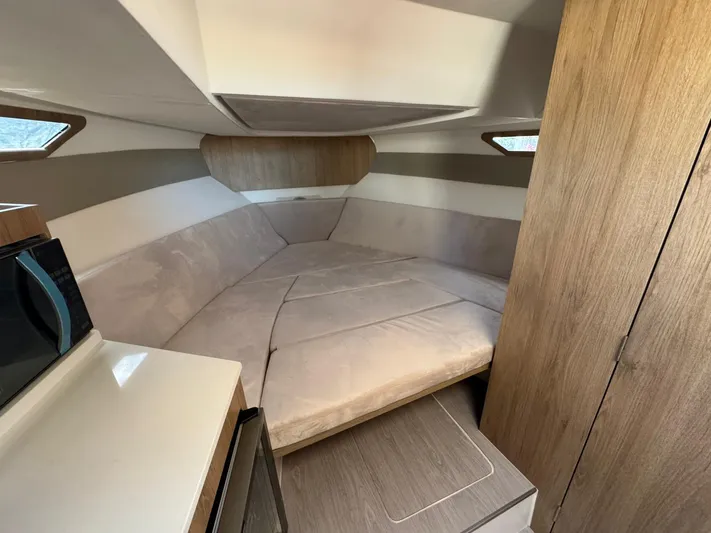  Yacht Photos Pics Interior cabin of 2025 NX Boats NX340, featuring cozy seating and modern wood finishes.