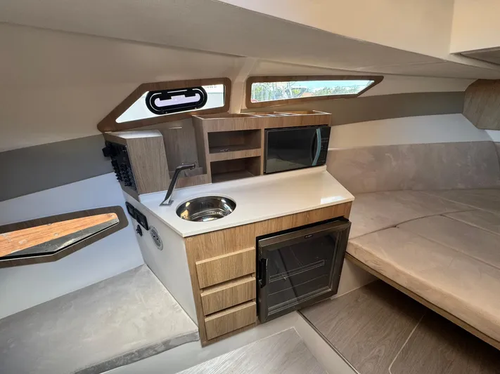  Yacht Photos Pics 2025 NX Boats NX340 interior with kitchenette, featuring sink, microwave, and compact fridge.