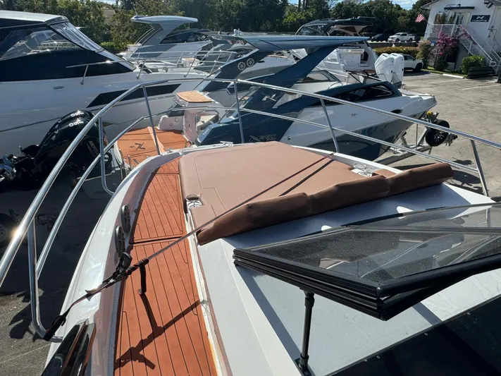  Yacht Photos Pics 2025 NX Boats NX340 yacht with sleek design and spacious deck, docked among other boats.