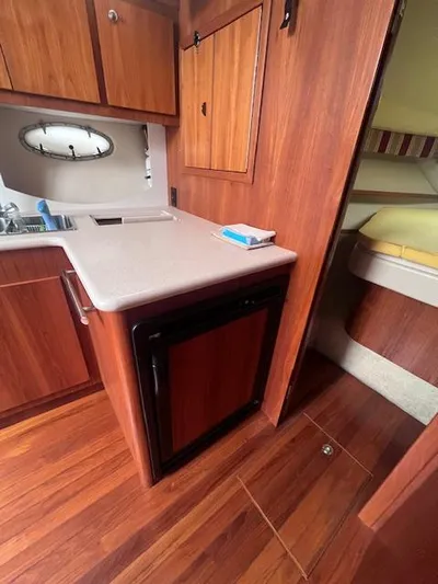 Getaway Yacht Photos Pics 2001 Tiara Yachts 3500 Express interior with wood cabinetry and compact kitchen area.