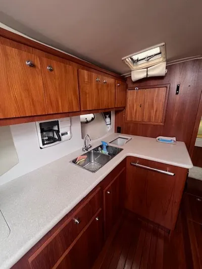 Getaway Yacht Photos Pics 2001 Tiara Yachts 3500 Express kitchen with wooden cabinets and modern sink.