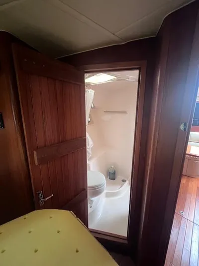 Getaway Yacht Photos Pics 2001 Tiara Yachts 3500 Express bathroom interior with wooden door and compact design.