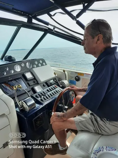 Getaway Yacht Photos Pics Man steering 2001 Tiara Yachts 3500 Express on open water.