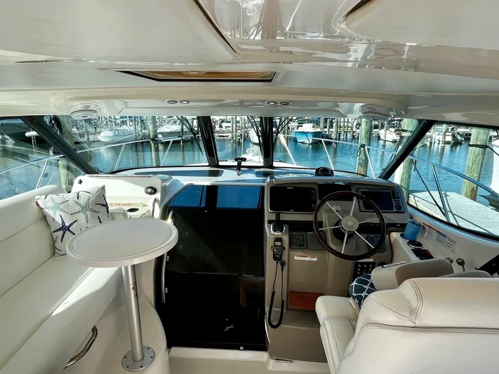 " Toes In The Sand " Yacht Photos Pics Interior of a 2011 Tiara Yachts Sovran with helm and seating area.