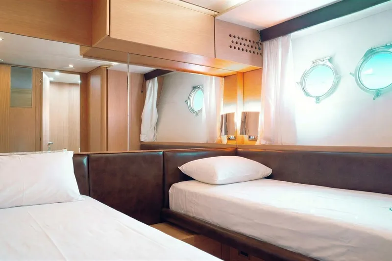  Yacht Photos Pics Luxurious cabin interior of 2015 Aicon 85 yacht with twin beds and porthole windows.