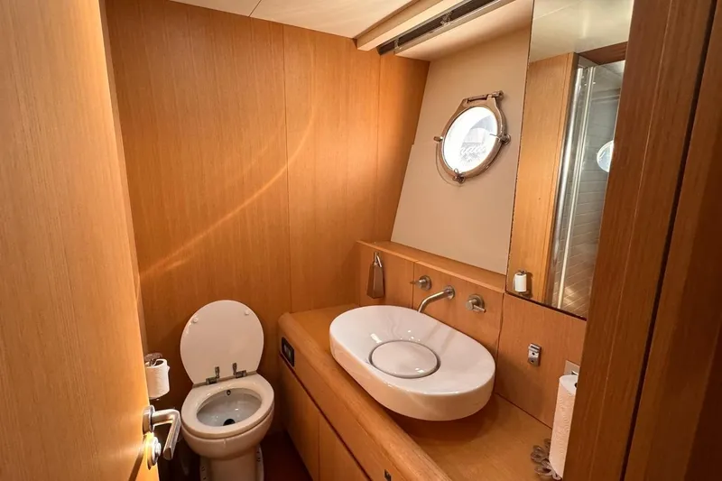  Yacht Photos Pics Luxurious bathroom interior of 2015 Aicon 85 yacht with wooden finish and porthole window.