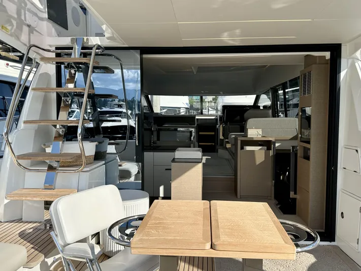 Pearl Voyage Yacht Photos Pics Luxurious 2023 Prestige 520 yacht interior with modern seating and elegant wooden table.