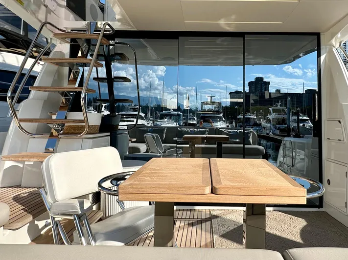 Pearl Voyage Yacht Photos Pics Luxurious 2023 Prestige 520 yacht interior with elegant wooden table and marina view.