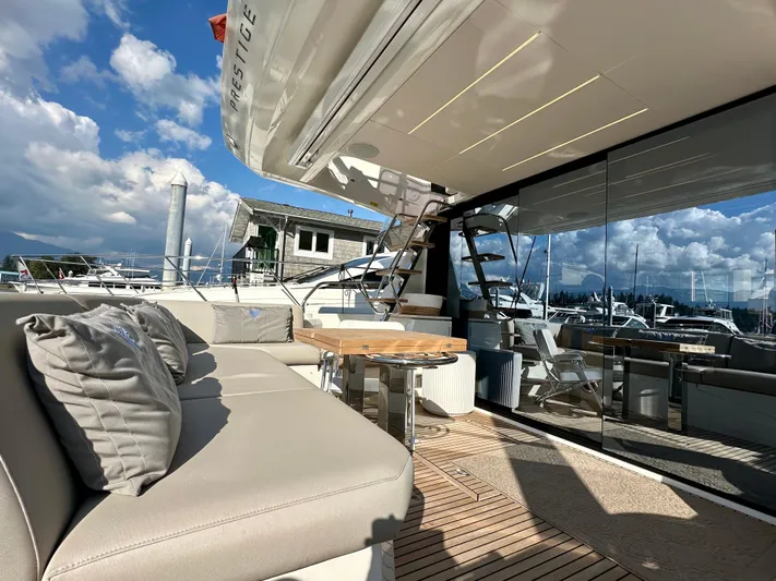 Pearl Voyage Yacht Photos Pics Luxurious 2023 Prestige 520 yacht deck with seating, table, and scenic marina view.