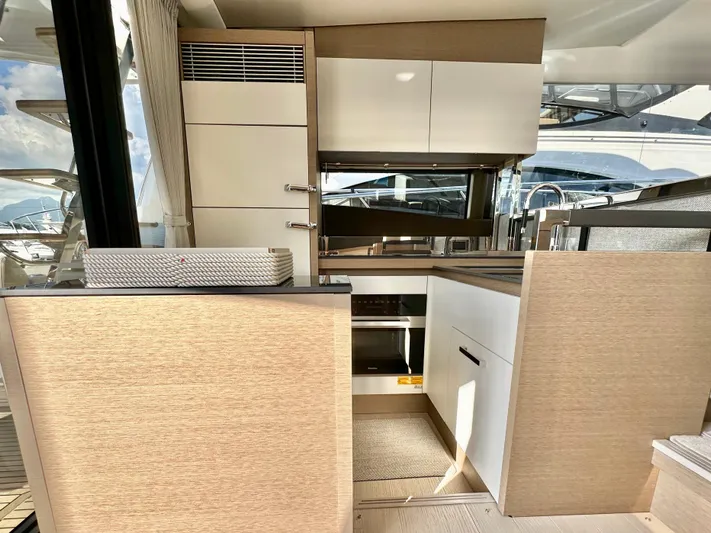 Pearl Voyage Yacht Photos Pics Modern kitchen interior on a 2023 Prestige 520 yacht, featuring sleek cabinetry and appliances.