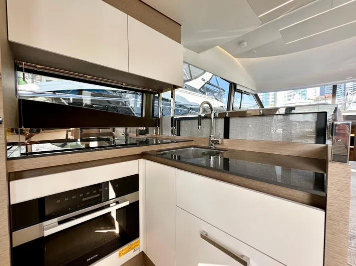 Pearl Voyage Yacht Photos Pics Modern kitchen interior on 2023 Prestige 520 yacht, featuring sleek cabinetry and appliances.