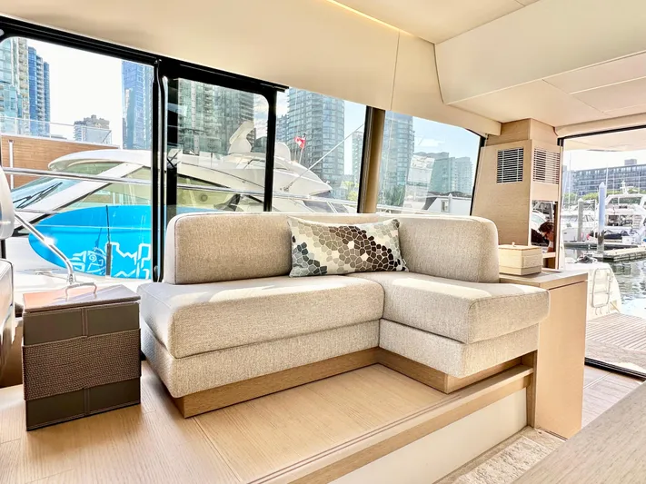 Pearl Voyage Yacht Photos Pics Luxurious interior of 2023 Prestige 520 yacht with modern sofa and marina view.