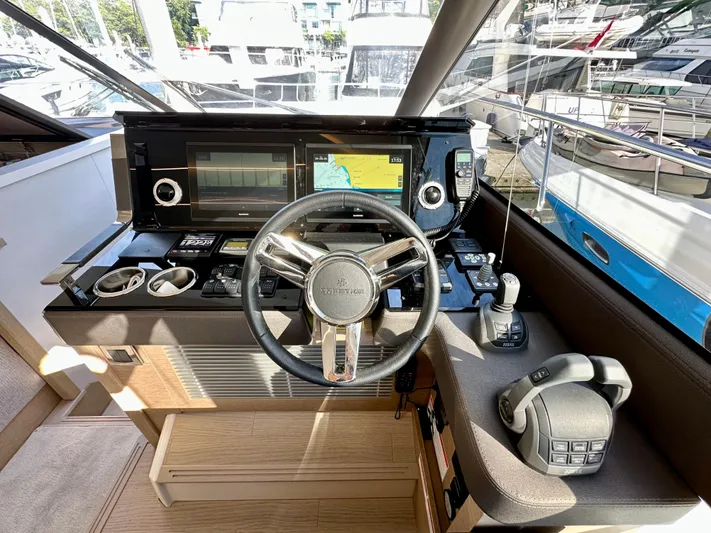 Pearl Voyage Yacht Photos Pics Cockpit of 2023 Prestige 520 yacht with modern navigation equipment and steering wheel.