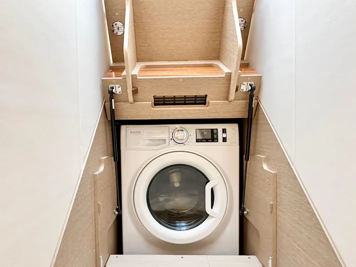 Pearl Voyage Yacht Photos Pics Compact laundry area with a built-in washing machine in a 2023 Prestige 520 model.