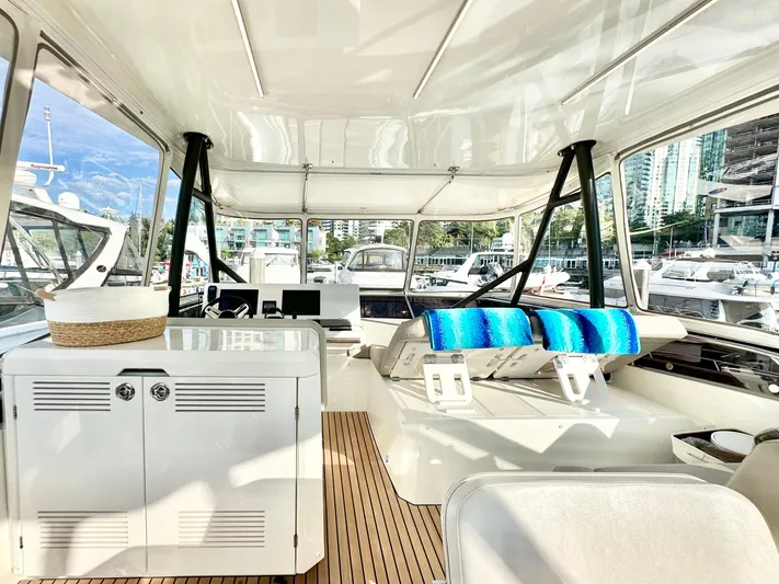 Pearl Voyage Yacht Photos Pics Luxurious 2023 Prestige 520 yacht interior with modern helm and seating, docked at marina.