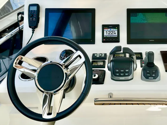 Pearl Voyage Yacht Photos Pics Control panel of 2023 Prestige 520 yacht with steering wheel and navigation screens.