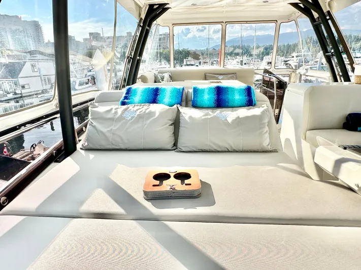 Pearl Voyage Yacht Photos Pics Luxurious 2023 Prestige 520 yacht interior with plush seating and scenic marina view.