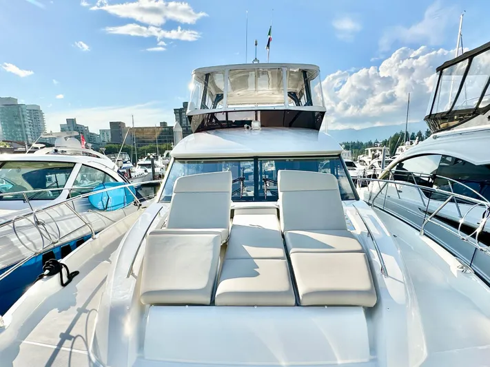 Pearl Voyage Yacht Photos Pics Luxury 2023 Prestige 520 yacht docked in a marina under a clear blue sky.