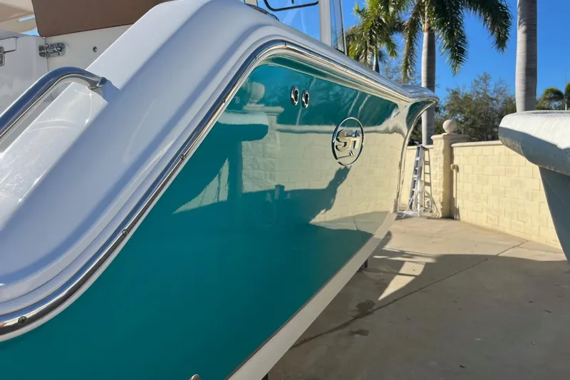  Yacht Photos Pics 2021 Sea Hunt Gamefish 27 Coffin Box boat with teal hull, docked near palm trees.