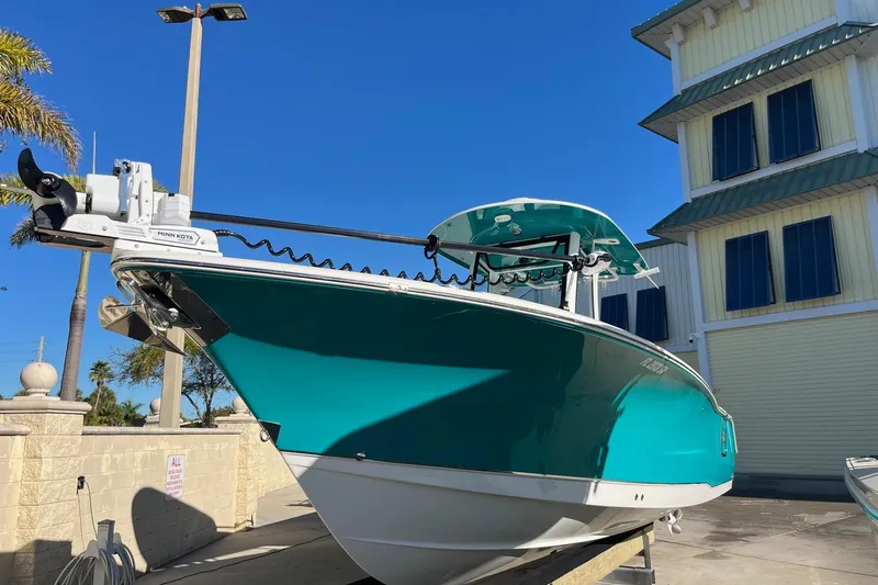  Yacht Photos Pics 2021 Sea Hunt Gamefish 27 Coffin Box boat, teal hull, docked near a building.