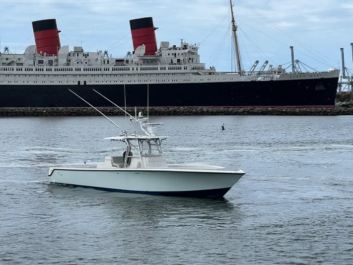 Part Time Hooker Yacht Photos Pics 2009 SeaVee IPS boat cruising near a large historic ship in a harbor.