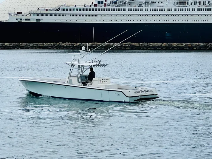 Part Time Hooker Yacht Photos Pics 2009 SeaVee IPS boat cruising near a large ship in calm waters.