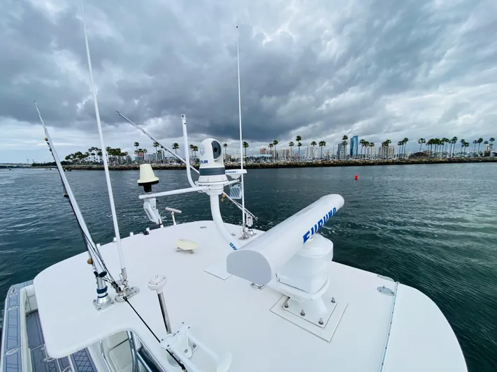 Part Time Hooker Yacht Photos Pics 2009 SeaVee IPS boat with radar equipment, cruising near palm-lined shore under cloudy skies.