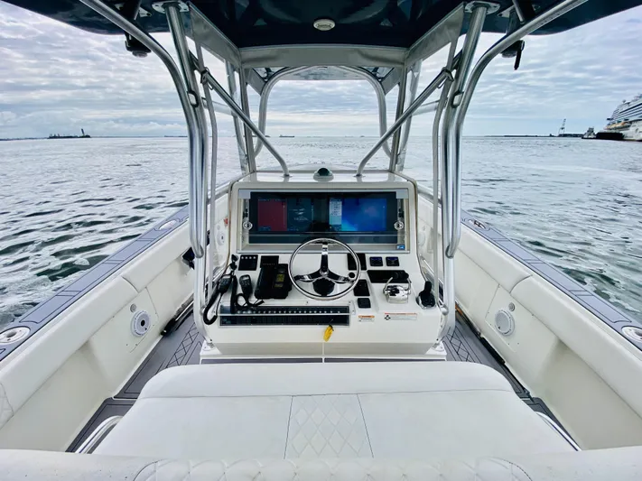 Part Time Hooker Yacht Photos Pics 2009 SeaVee IPS boat cockpit with steering wheel and navigation screens on open water.