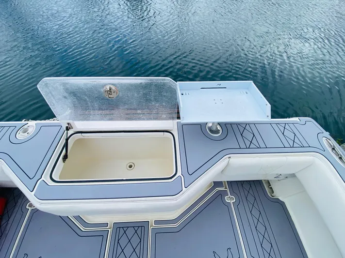 Part Time Hooker Yacht Photos Pics 2009 SeaVee IPS boat deck with open storage compartment, featuring sleek design and water backdrop.